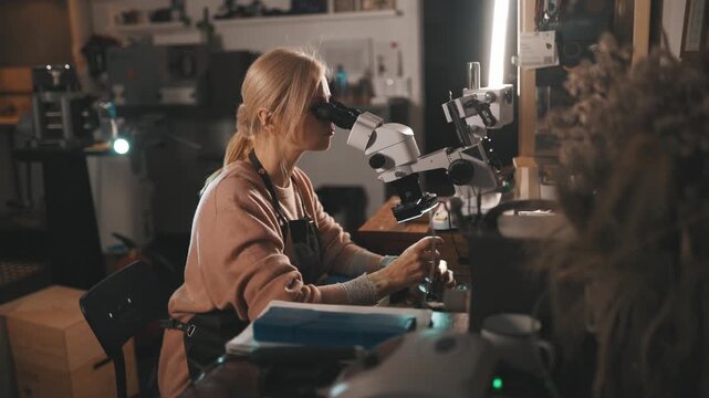 Jeweler examining precious stone using microscope