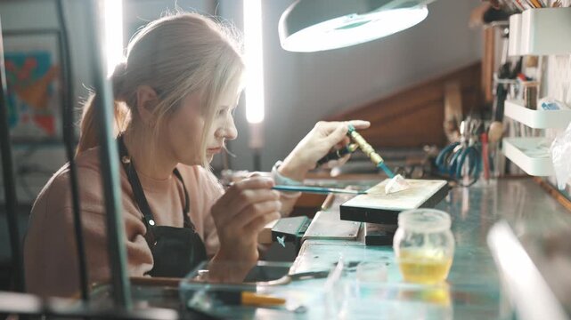 Jeweler soldering silver with a gas torch in workshop