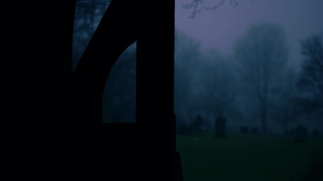 Lonely Graveyard on foggy day though view of lych gate