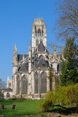 Obraz premium Saint Ouen Abbey Church in Rouen France on sunny spring day, abbey rising above fresh green grass and blue sky, abbey architecture glowing in daylight, abbey exterior surrounded by calm open space
