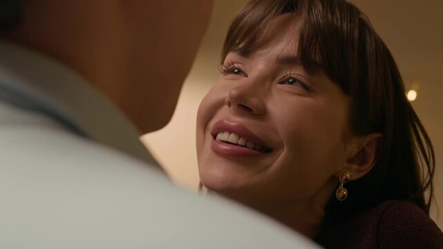 Close up shot of young Caucasian loving couple looking at each other while sharing intimate moment at home