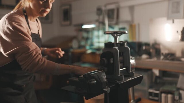 Focused female jeweler crafting in her workshop