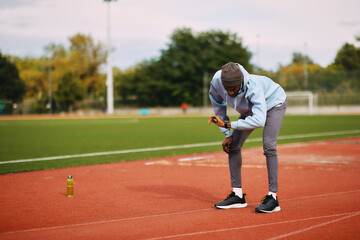 Athlete checking smartwatch during running break