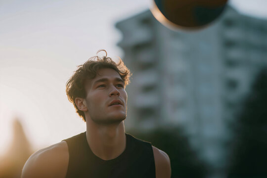 Athletic young man holding basketball at sunset, cinematic street sports portrait

