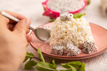 White Сottage cheese, Curd, with Pithaya with hand on gray concrete and linen textile, side view, close up, selective focus