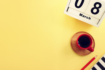 Wooden calendar indicating March 8th, International Women's Day, yellow background
