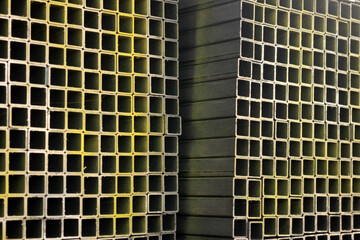 Obraz premium Close-up of stacked square steel hollow section profiles with clean cut edges stored inside an industrial metal warehouse