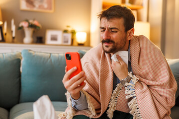 Sick man having online doctor's appointment using smart phone