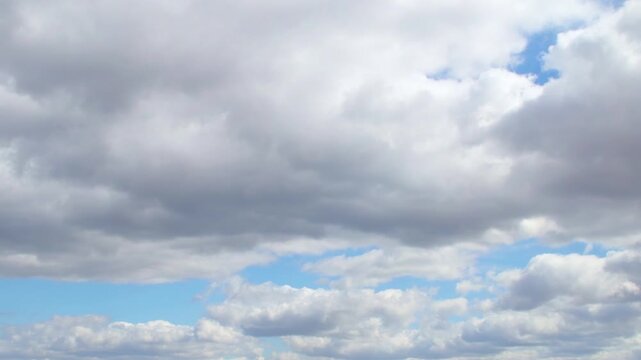 Dramatic sky almost completely covered with cumulus clouds. Slowly moving huge clouds. Atmosphere before a storm or rain.