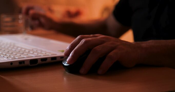 Hand Using Mouse While Working on Laptop, Close-Up of Computer Workspace