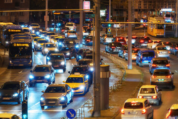 city streets and road traffic in Budapest, Hungary, at night. Street lights and random people