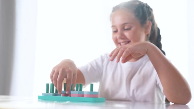 Boy is playing with toys to develop his motor skills. Learn color nursery concept. Child is playing with rings. Child lifestyle is developing skills in developing motor skills with a ring of toys.