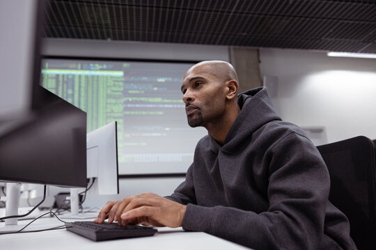 Concentrated man coding in a modern tech scene