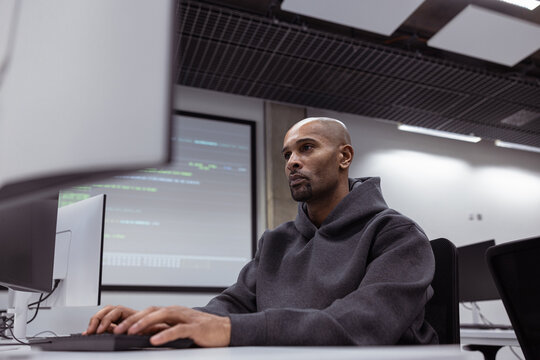 Focused man coding at a modern tech workspace setup