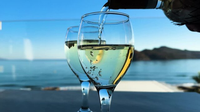 pouring wine into two glasses of cretan wine on Agia Marina beach, Crete Greece, toned