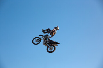 Motorcycle rider performing dangerous midair stunt trick