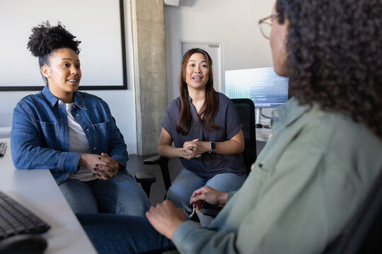 Women discussing ideas in a tech-savvy workplace