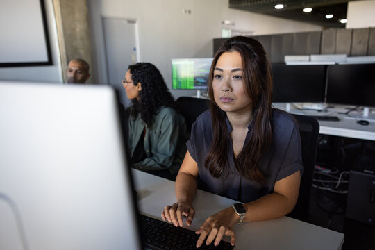 Focused woman working at a computer in an office