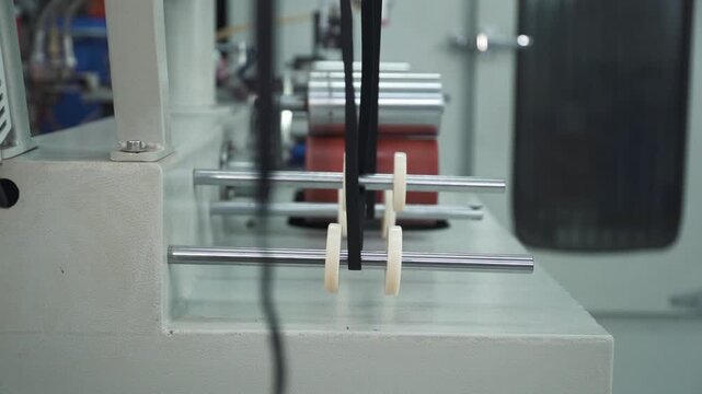traking in of black elastic tape running through a machine in a textile factory