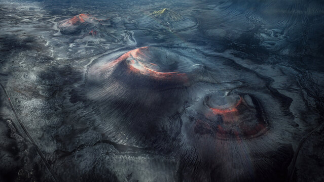 Aerial view of volcanic cones ablaze with fiery orange hues amidst the stark, grey landscape of Landmannaleid, Fjallabak, Rangarthing ytra, Iceland.