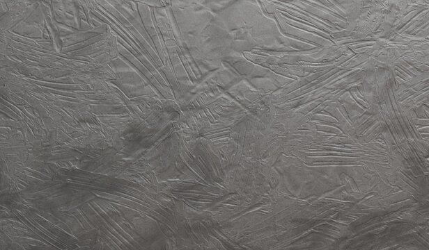 This abstract image displays a cool grey, highly textured surface with myriad raised, sharp, angular patterns, suggesting frozen water or rough metal