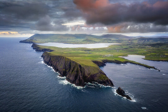 Aerial view of dramatic cliffs meet the turbulent sea under a brooding sky, Sybil Head, County Kerry, Ireland.