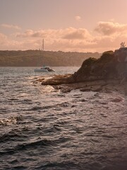 Rocky Coastline at Sunset with Boat on the Water