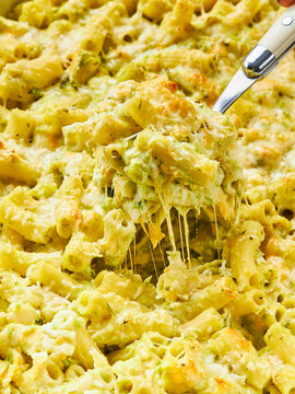 Close-up of a fork in a baking dish of macaroni gratin