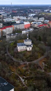 Vertical drone shot around the Vartiovuori Observatory, cloudy day in Turku