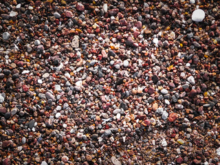 Sand, gravel and small shells on the seashore as a natural background.