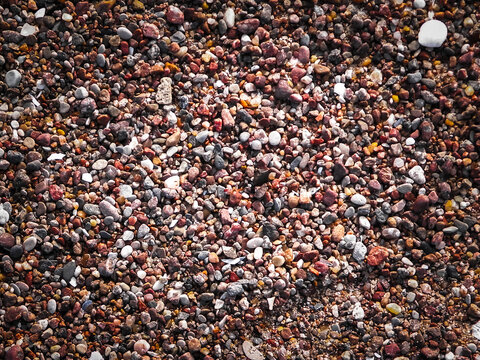 Sand, gravel and small shells on the seashore as a natural background.