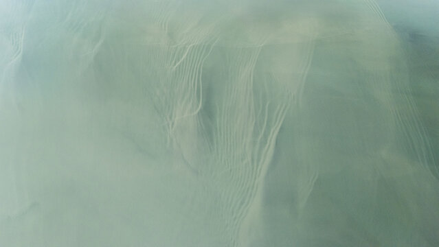 Aerial view of murky waters with intricate patterns creating ethereal beauty in an abstract composition, Selfoss, Iceland.
