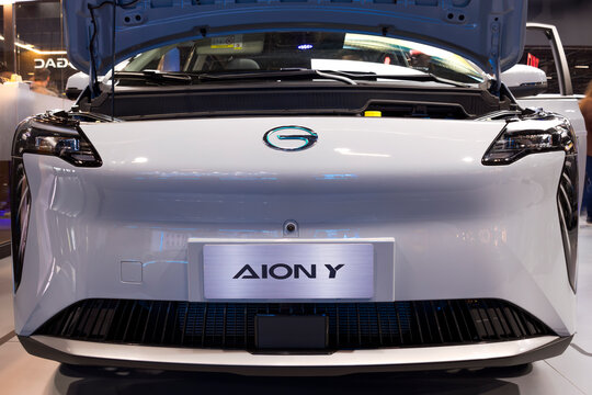 Front view of the Aion Y electric vehicle with hood open, highlighting LED lighting assembly, front camera, and aerodynamic lower grille.