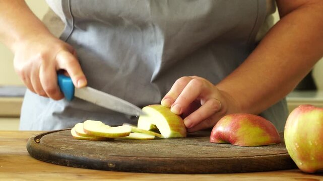 Woman cuts apples and pears for pie
