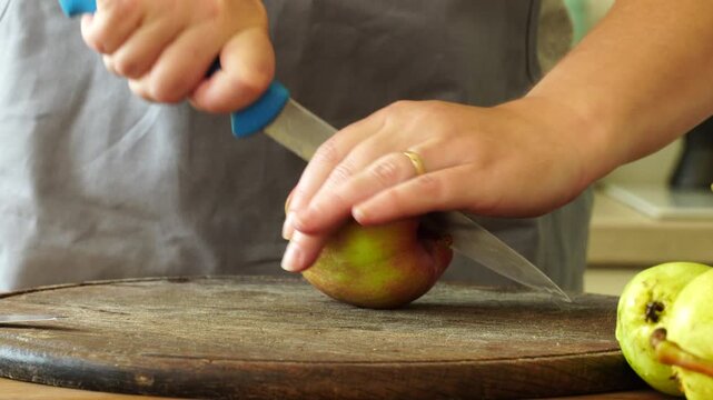Woman cuts apples and pears for pie
