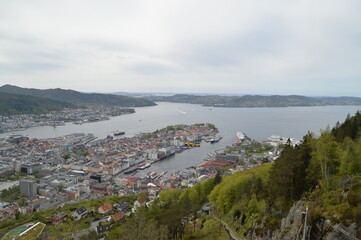 Obraz premium Panoramablick über Bergen in Norwegen mit Hafen, Fjord und umliegenden Bergen. Naturnahe Stadtlandschaft mit maritimem Flair, ideal für Reise, Natur und skandinavische Atmosphäre.