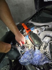 Fototapeta premium Oil and filter change on an old Skoda car. Close-up shots of motor oil pouring, filter replacement, and engine bay during routine garage maintenance Focus on precision.