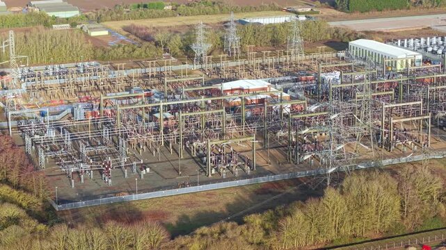 Wide drone perspective of National Grid Walpole substation showing massive power line arrays and electrical engineering during Great Grid Upgrade.