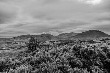 A black and white photo of a mountain range with a cloudy sky