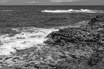 The ocean is calm and the rocks are jagged