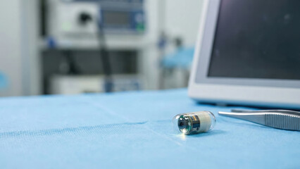 Surgery technology ai diagnostics ar overlay medical capsule on blue drape near monitor and tool in sterile operating room