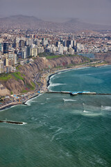 Obraz premium Aerial summer view of Malecon Miraflores and Lima’s Costa Verde, showcasing the dramatic Pacific coastline, urban cliffs of Miraflores and Barranco, vibrant ocean waters, and the dynamic blend of city