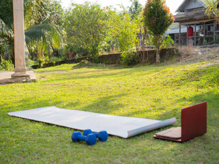 Laptop, mat and dumbbells with fitness equipment or interior on floor for online tutorial at home. Empty room or space with computer, technology or weights for health, wellness or tools for exercise