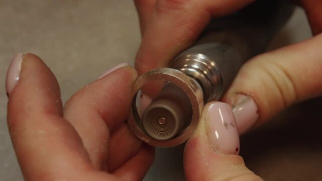 Professional jeweler polishing gold ring on rotary machine.