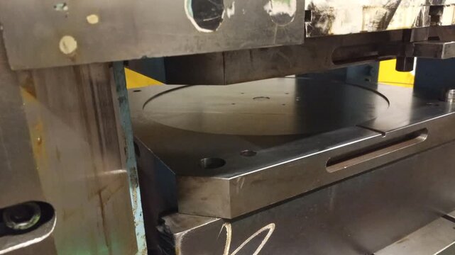 Industrial hydraulic press machine shaping a metal sheet in a factory