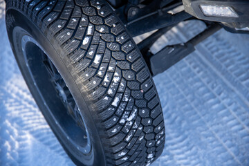 Close-up of studded tire on snowy road for safe winter driving