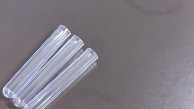 Transparent test tubes aligned on laboratory bench, left composition