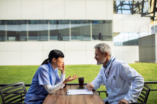 Healthcare colleagues discussing case in hospital courtyard