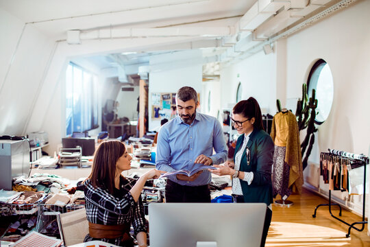 Fashion team reviewing designs in modern studio