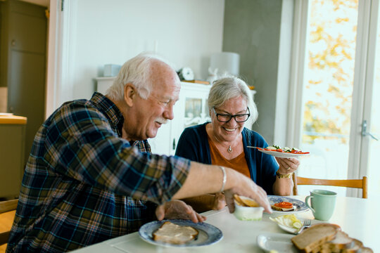 Senior couple enjoying breakfast at home kitchen table